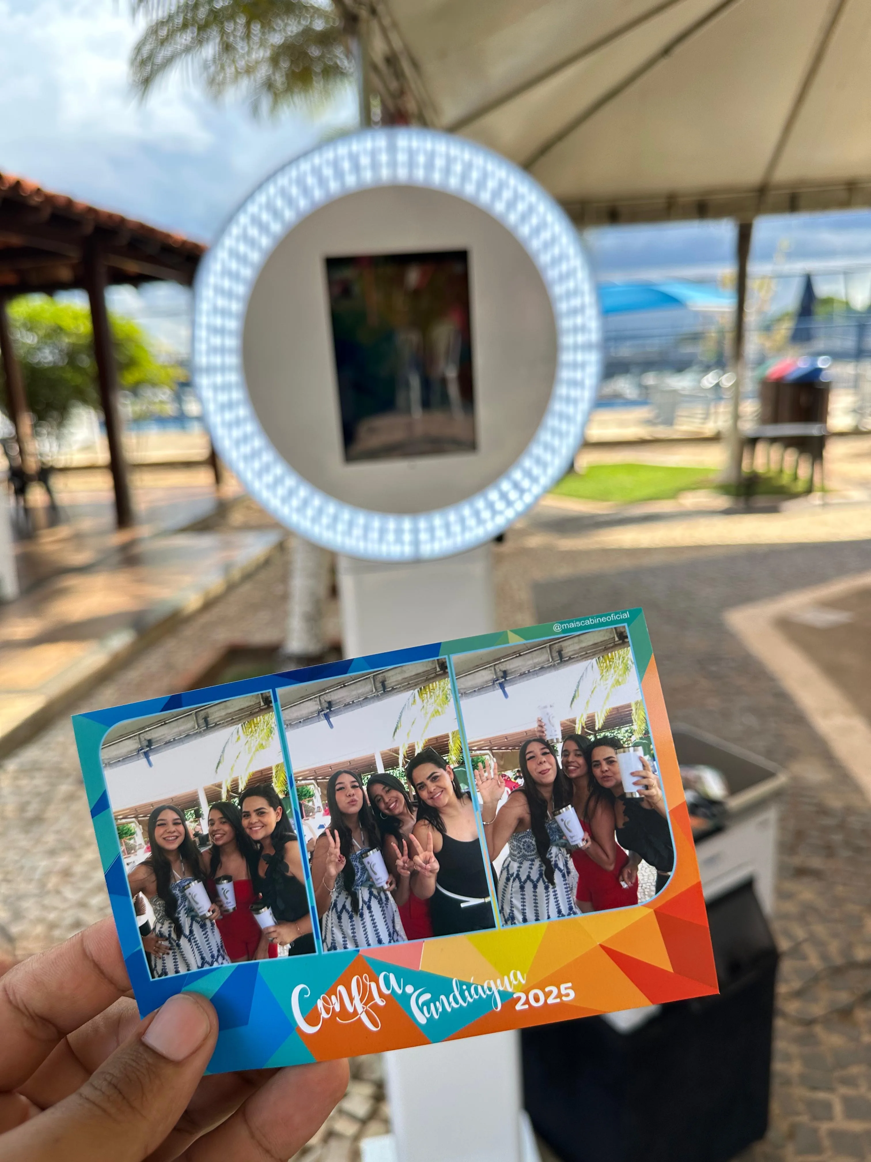 Convidado segurando a foto impressa na hora com a moldura da festa